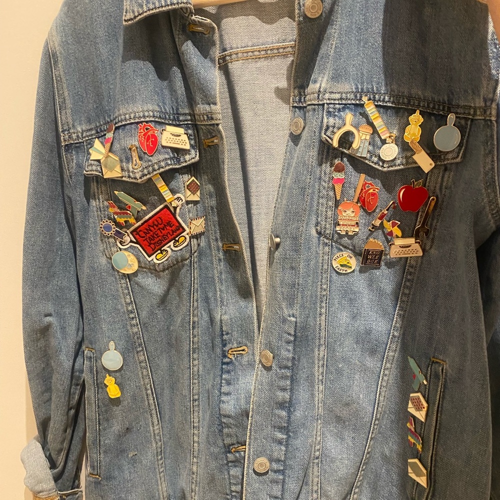 Selling denim jacked with pins and patches .